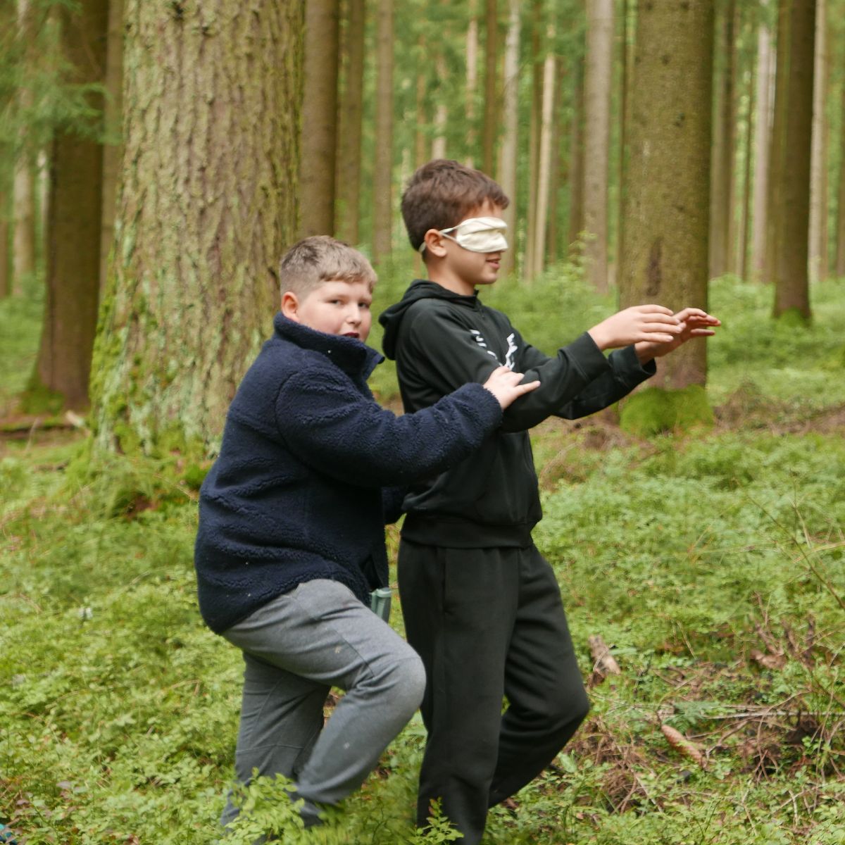 Kinder spielen blind im Wald