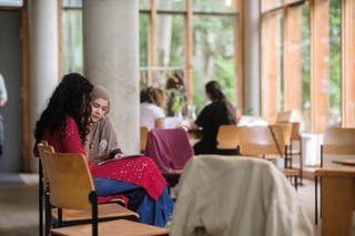 Menschen sitzen in einem Café, unterhalten sich.