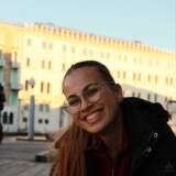 Lächelnde Person vor Gebäude